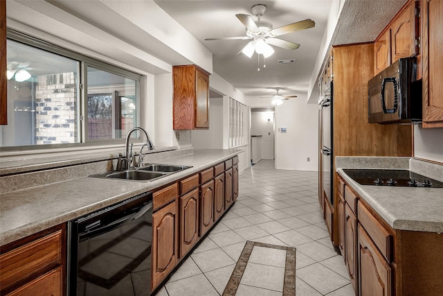 kitchen featuring brown cabinetry, visible vents, a sink, and black appliances