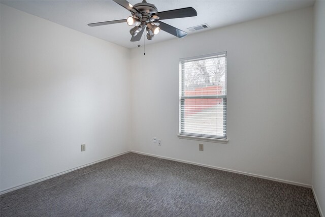 spare room featuring ceiling fan, plenty of natural light, and dark carpet