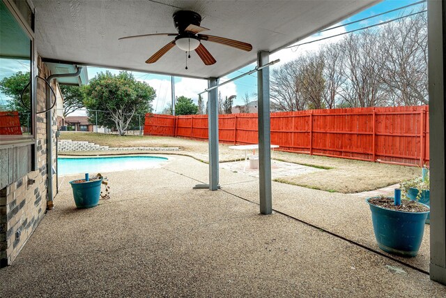 view of swimming pool with ceiling fan, a yard, and a patio