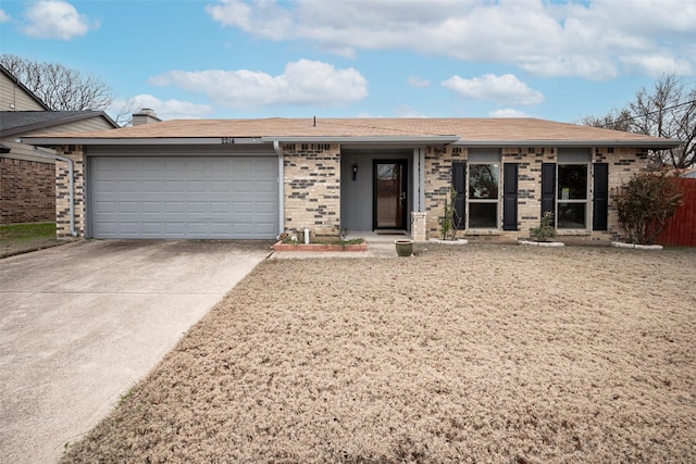 ranch-style home featuring a garage, driveway, and brick siding