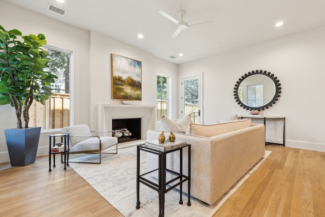 living room with light hardwood / wood-style floors and ceiling fan