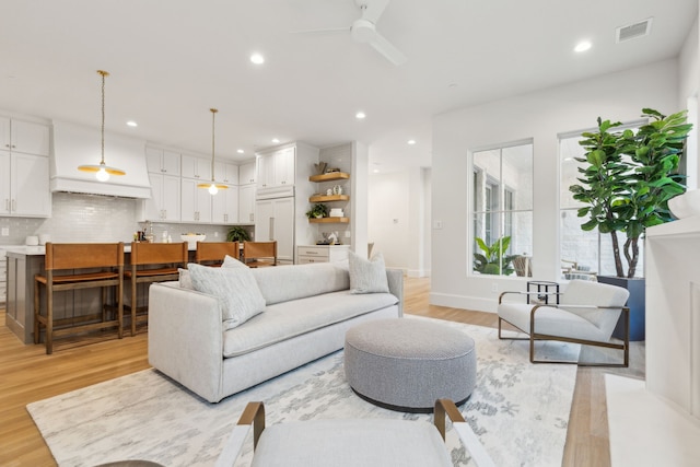 living room featuring ceiling fan and light hardwood / wood-style flooring