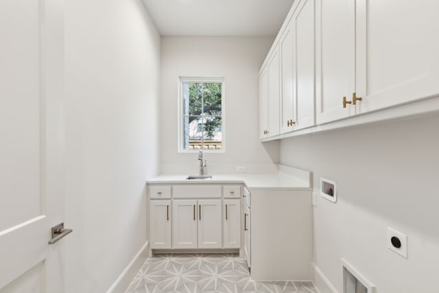 clothes washing area with cabinets, electric dryer hookup, sink, hookup for a washing machine, and light tile patterned floors