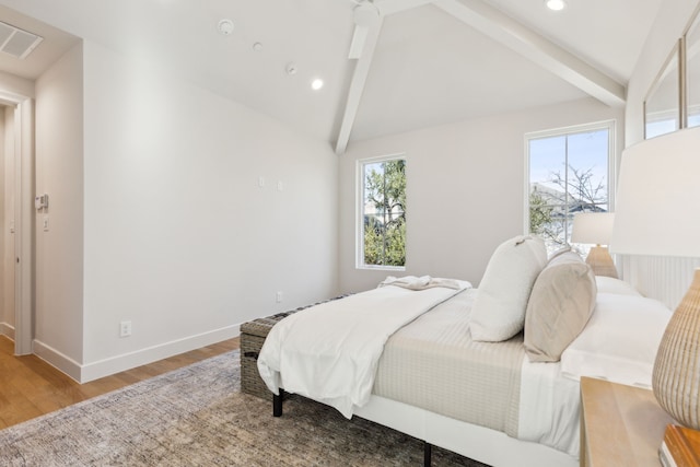 bedroom with wood-type flooring and vaulted ceiling with beams