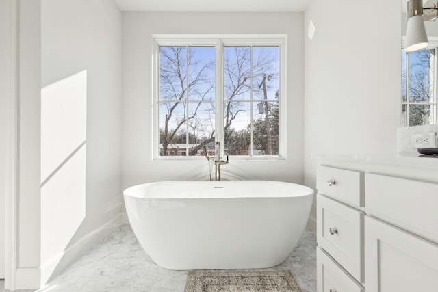 bathroom featuring vanity, a wealth of natural light, and a washtub