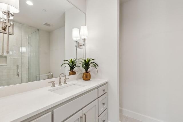 bathroom featuring walk in shower and vanity