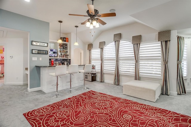 kitchen featuring light colored carpet, a kitchen bar, and hanging light fixtures