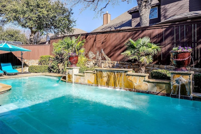 view of swimming pool with pool water feature