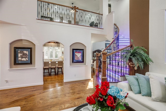 foyer entrance featuring hardwood / wood-style flooring and a towering ceiling