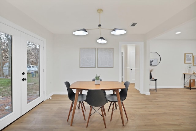 dining area featuring french doors and light wood-type flooring