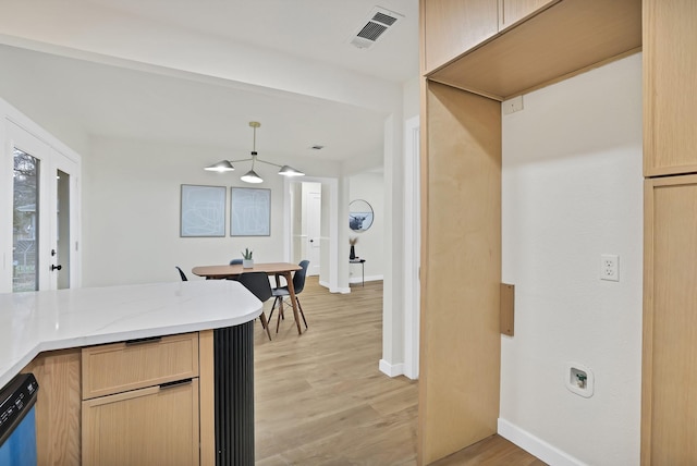 kitchen featuring light brown cabinetry, dishwasher, and light hardwood / wood-style flooring