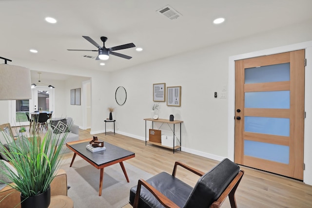 living room featuring ceiling fan and light hardwood / wood-style floors