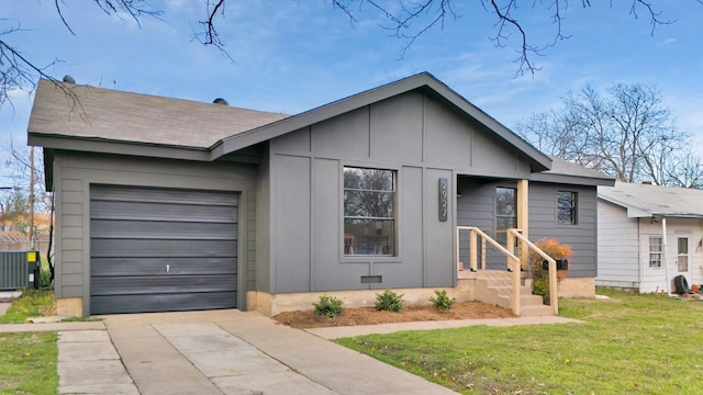 view of front of property with a front lawn, a garage, and cooling unit