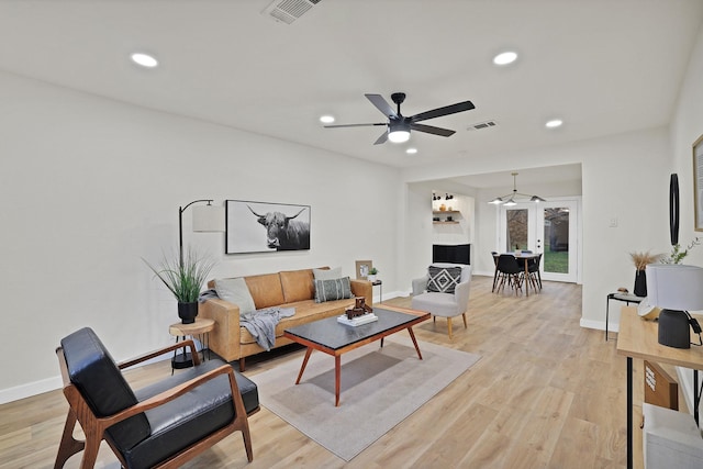 living room featuring ceiling fan, light hardwood / wood-style floors, and french doors