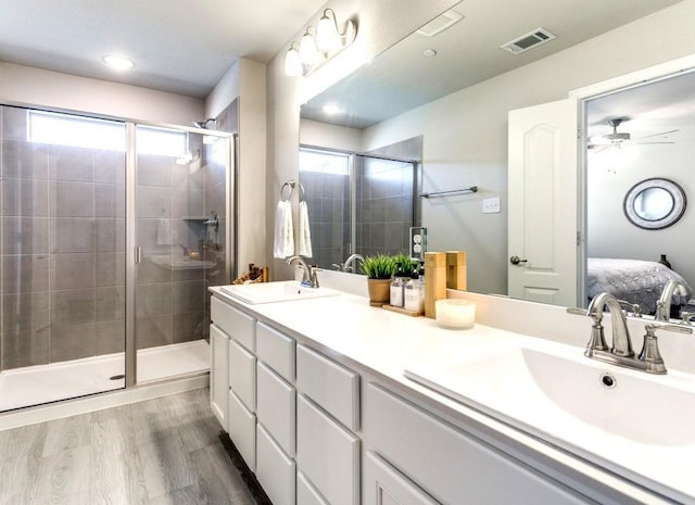 bathroom with ceiling fan, a healthy amount of sunlight, wood-type flooring, and vanity