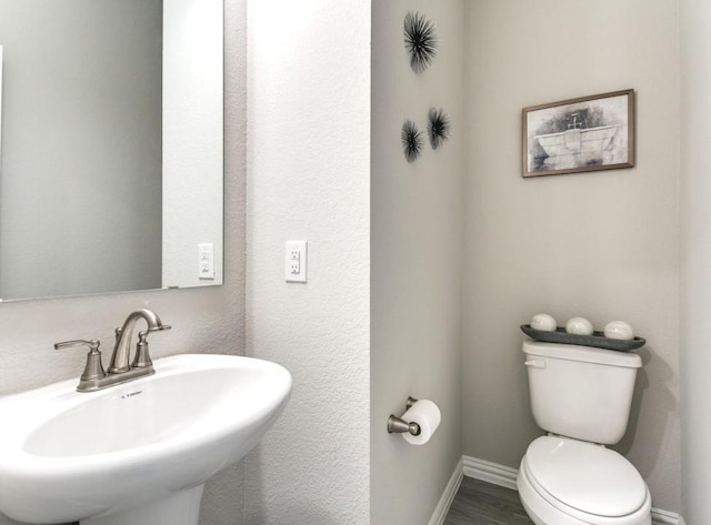 bathroom featuring toilet, hardwood / wood-style flooring, and sink