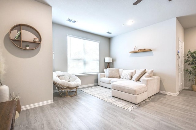 living room with ceiling fan and light wood-type flooring