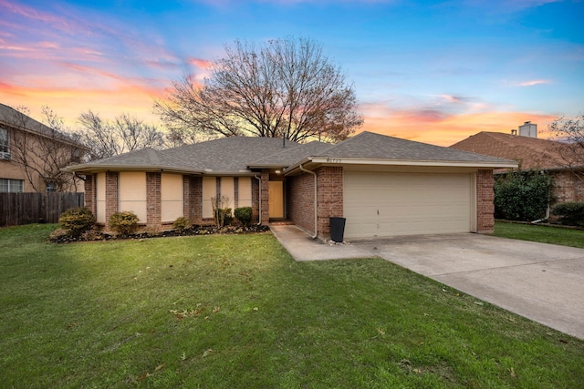 single story home with a garage and a lawn