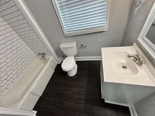 bathroom with toilet, a bath, hardwood / wood-style floors, and vanity