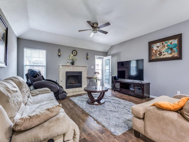 living room with ceiling fan, vaulted ceiling, dark hardwood / wood-style floors, and a tile fireplace