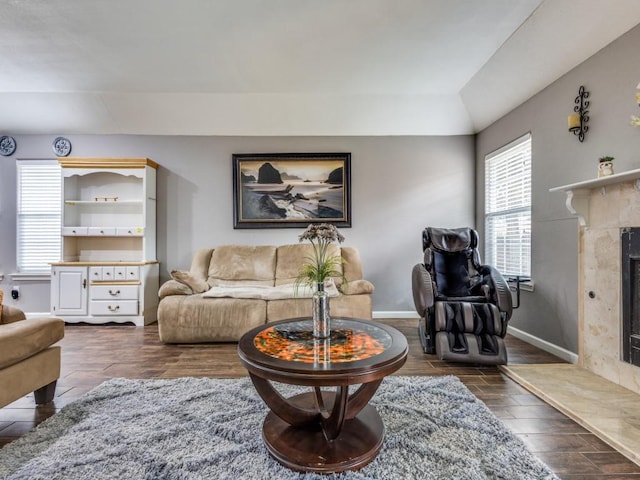 living room featuring a premium fireplace and vaulted ceiling