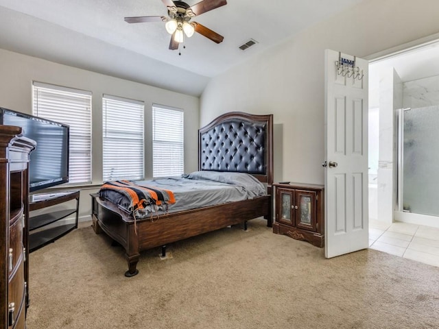 bedroom with ceiling fan, light carpet, vaulted ceiling, and connected bathroom