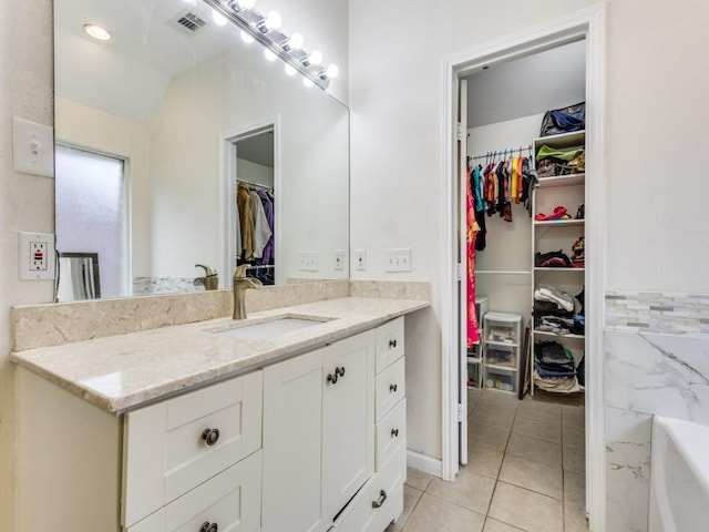 bathroom with tile patterned floors, vanity, and a bathing tub