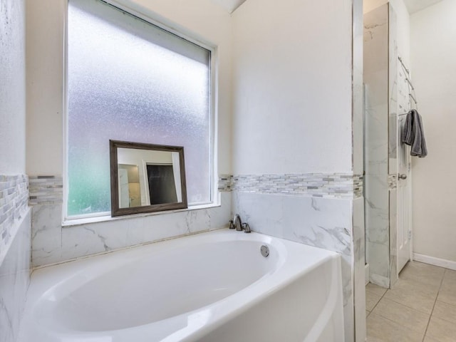 bathroom featuring tile patterned flooring and a tub to relax in