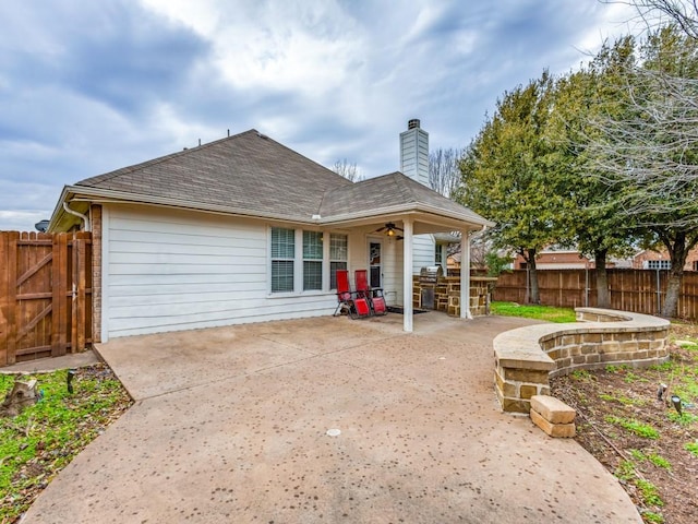 back of property featuring ceiling fan, a patio area, and an outdoor bar