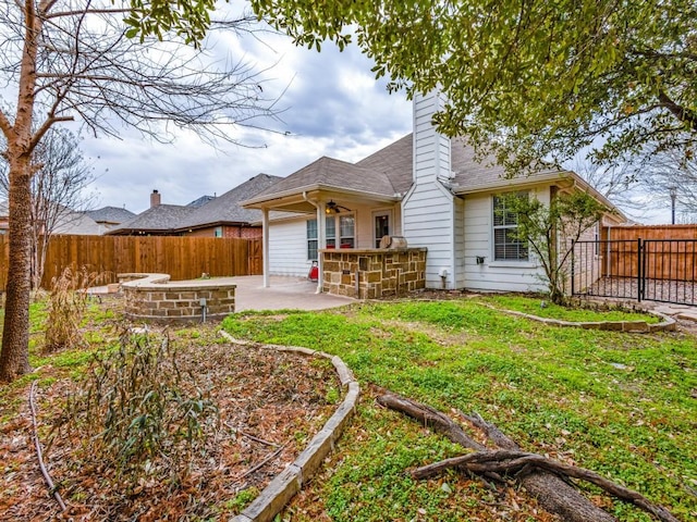 back of house with ceiling fan, a lawn, and a patio