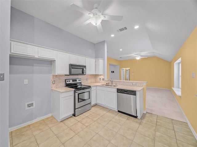 kitchen with vaulted ceiling, decorative backsplash, sink, stainless steel appliances, and white cabinets