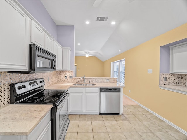 kitchen with appliances with stainless steel finishes, lofted ceiling, white cabinetry, sink, and light tile patterned floors