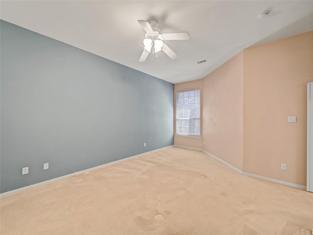 carpeted spare room featuring ceiling fan