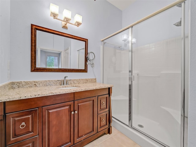 bathroom with a shower with door, vanity, and tile patterned flooring