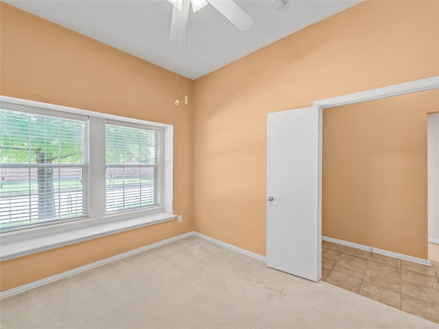 spare room featuring ceiling fan and light carpet