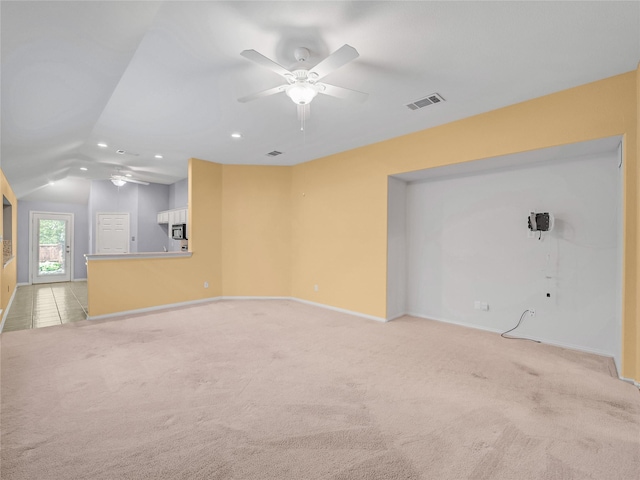 unfurnished living room featuring vaulted ceiling, ceiling fan, and light colored carpet