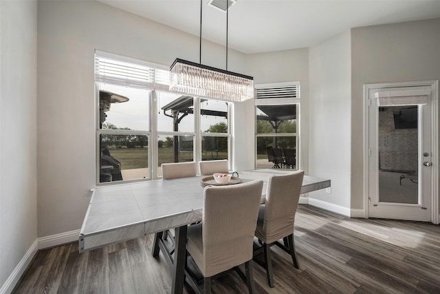 dining room with dark wood-type flooring and a chandelier