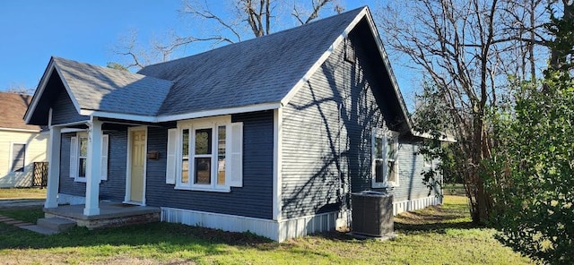 view of front of house featuring a front lawn and central AC