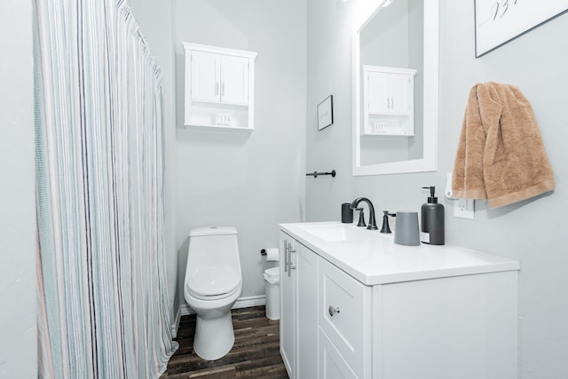 bathroom featuring toilet, wood-type flooring, and vanity