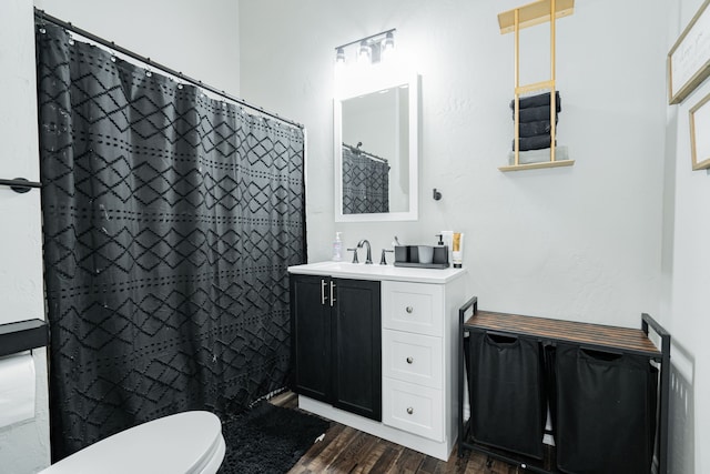 bathroom with hardwood / wood-style floors, toilet, vanity, and a shower with shower curtain