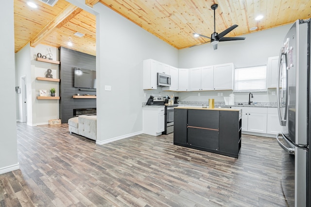 kitchen with beamed ceiling, appliances with stainless steel finishes, wood ceiling, high vaulted ceiling, and white cabinets