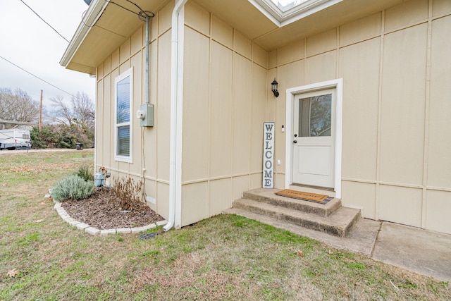 doorway to property with a lawn