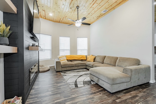 living room featuring ceiling fan, dark wood-type flooring, a towering ceiling, and wood ceiling