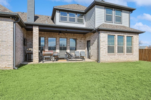 rear view of house featuring ceiling fan, a patio area, and a yard