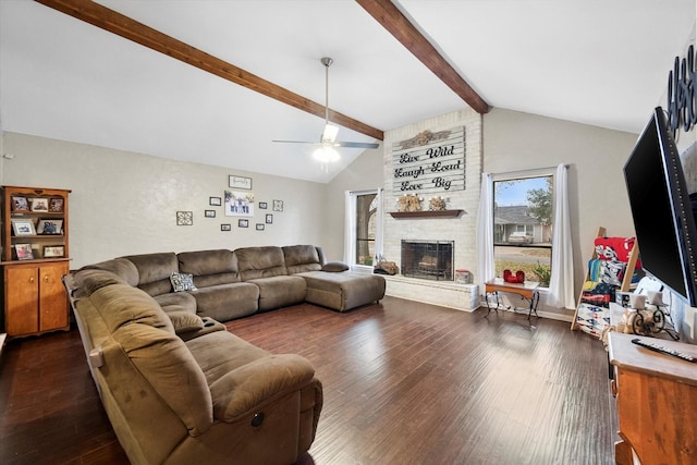 living room featuring ceiling fan, dark hardwood / wood-style flooring, a brick fireplace, and lofted ceiling with beams