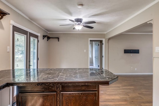 kitchen with ceiling fan, crown molding, hardwood / wood-style flooring, a textured ceiling, and dark brown cabinets