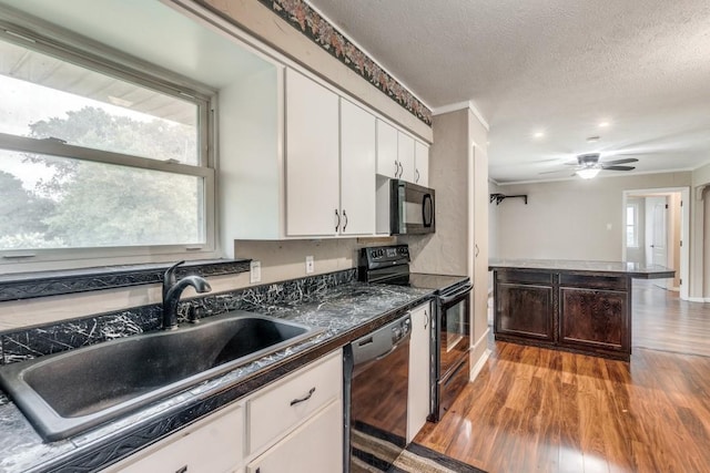 kitchen with white cabinetry, light hardwood / wood-style floors, ornamental molding, black appliances, and sink