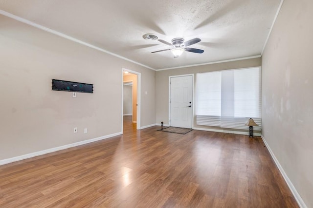 empty room featuring ceiling fan, hardwood / wood-style floors, crown molding, and a textured ceiling