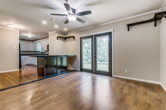 kitchen with white cabinetry, french doors, light hardwood / wood-style floors, kitchen peninsula, and crown molding