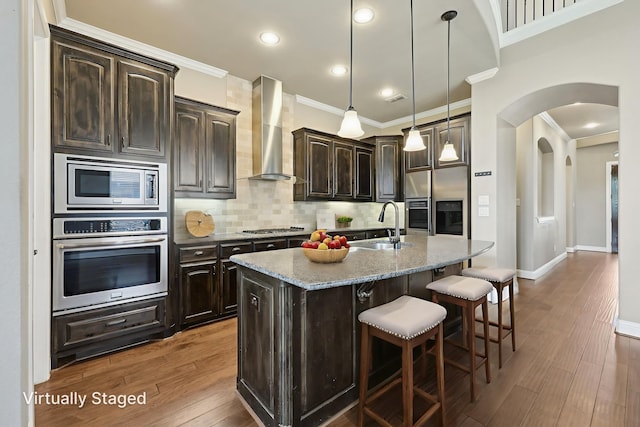 1776 Halifax St, Roanoke, TX 76262 - kitchen featuring stainless steel appliances, wall chimney range hood, a sink, crown molding, and a breakfast bar